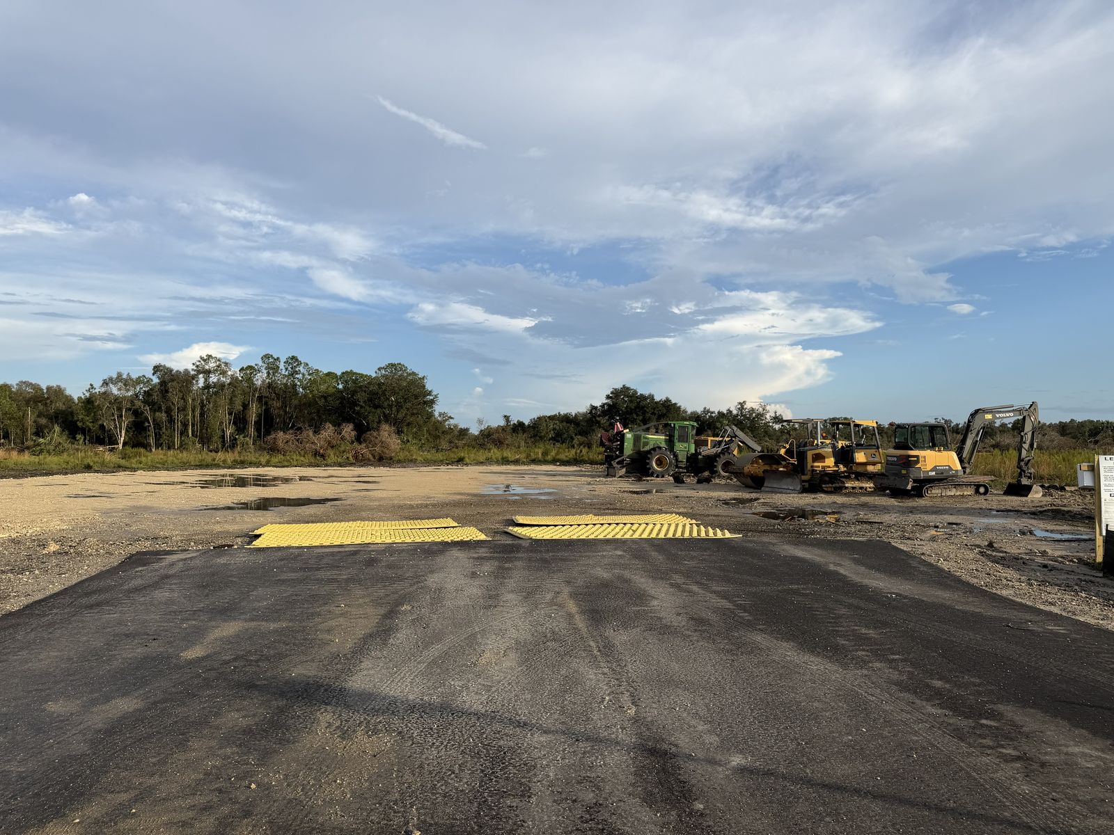 The new paved construction entrance, with equipment parked on the cleared pad. Photo: Fernando Daza, October 11, 2026.